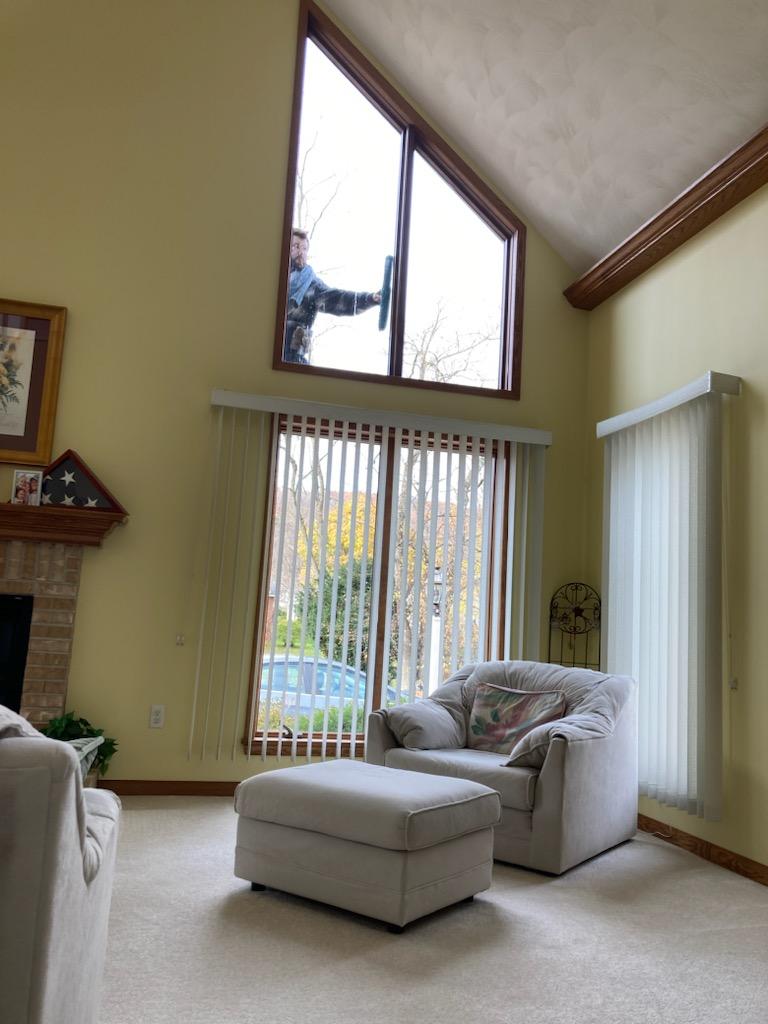 Owner of 814 window washing cleaning window on outside of home